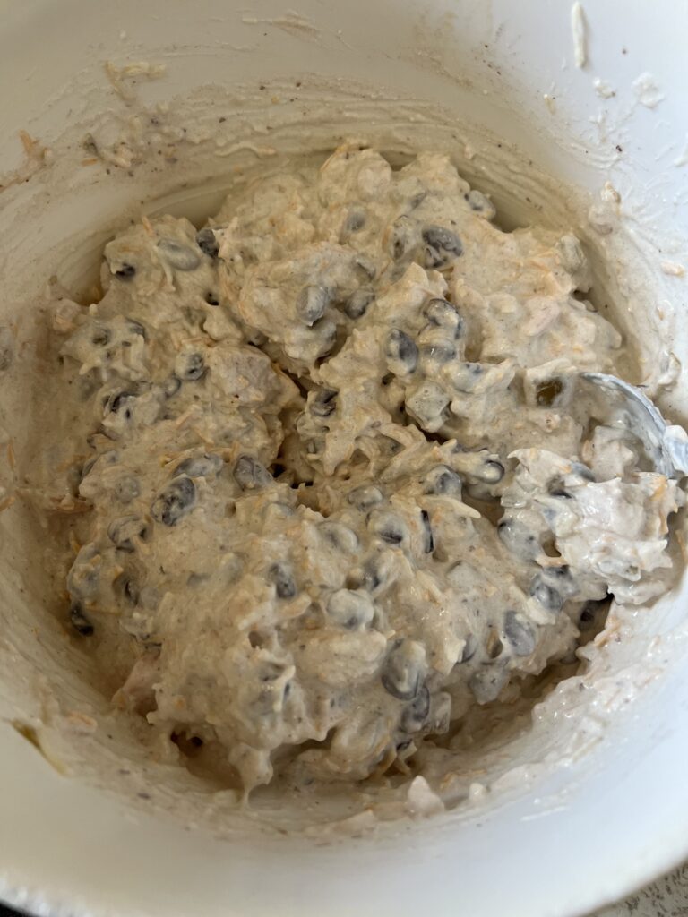enchilada filling with black beans, sour cream, chicken, cheese, onion, and green chiles