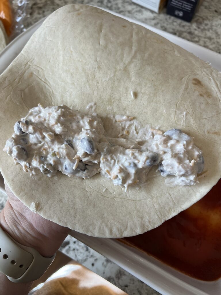 enchilada filling on once edge of the tortilla