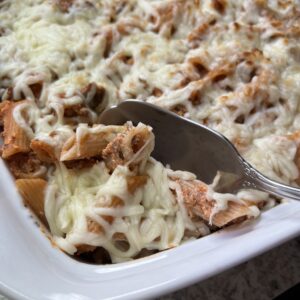 fake baked ziti pasta being scooped out of a baking dish