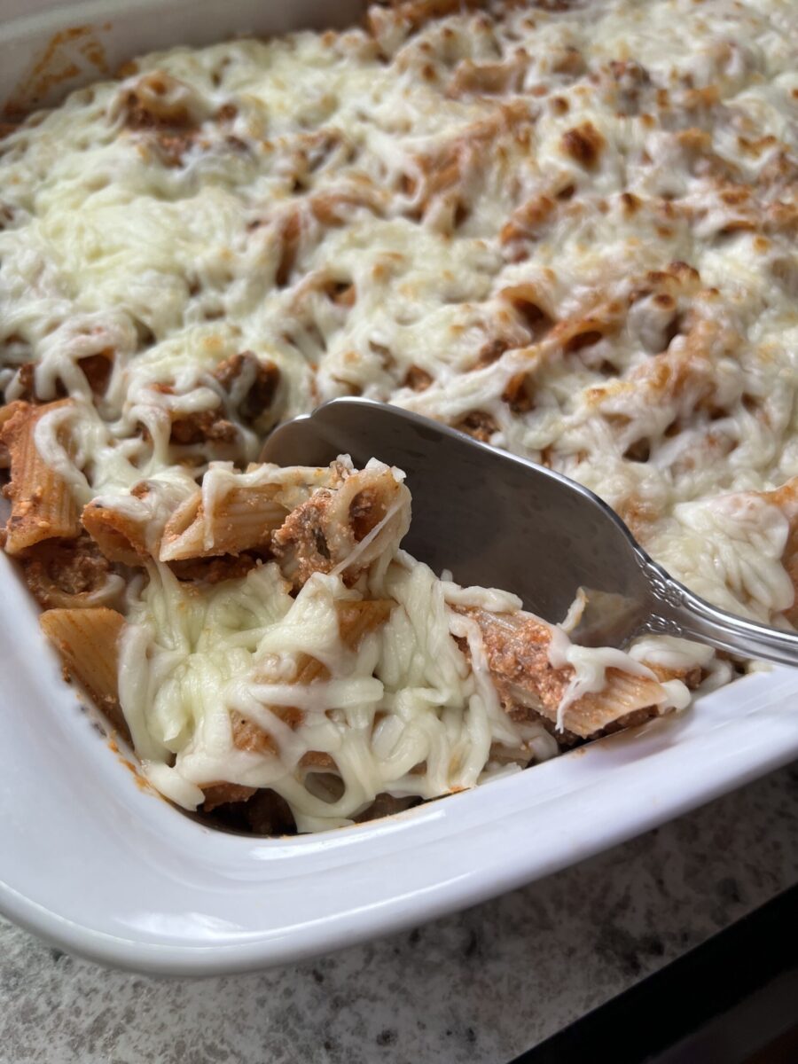 fake baked ziti pasta being scooped out of a baking dish